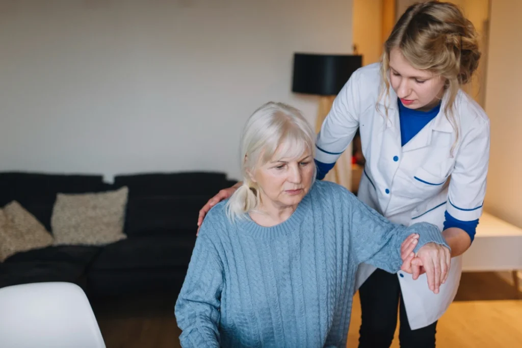 une infirmière qui aide une femme agée