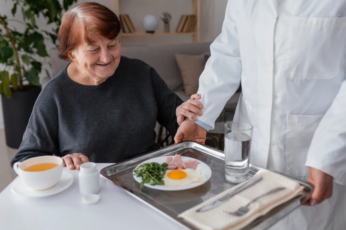une femme agée servi d'un repas